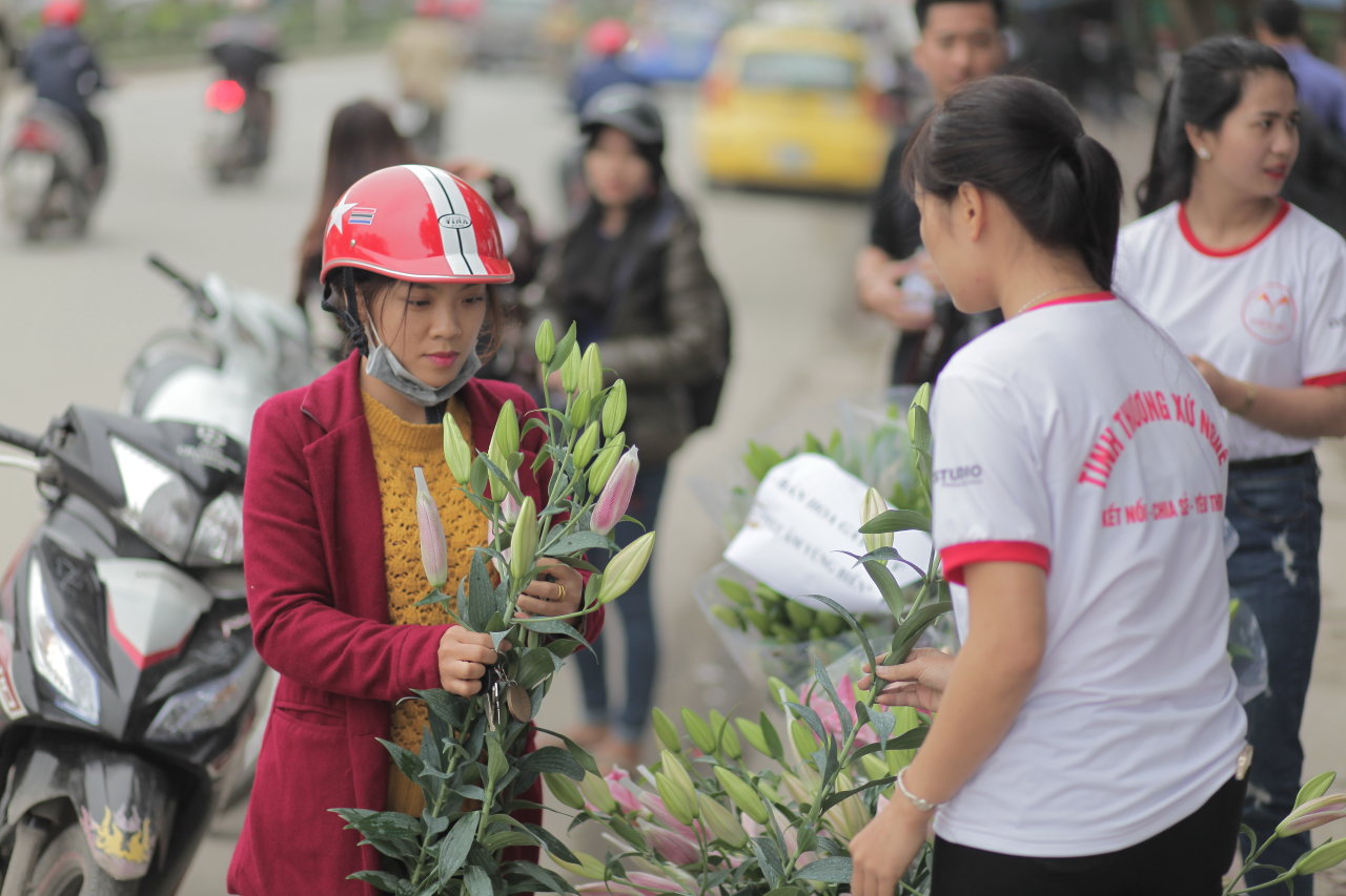 Nhóm bạn trẻ CLB tình nguyện Tình thương xứ Nghệ bán hoa gây quỹ - Ảnh: D.Hòa