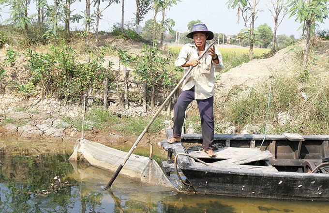 Ông Nguyễn Văn Láng (ấp 3, xã Tân Phước, huyện Gò Công Đông) chuẩn bị bơm nước lên ruộng cứu lúa. Tuy nhiên, nước dưới kênh cũng không còn bao nhiêu - Ảnh: V.TR.