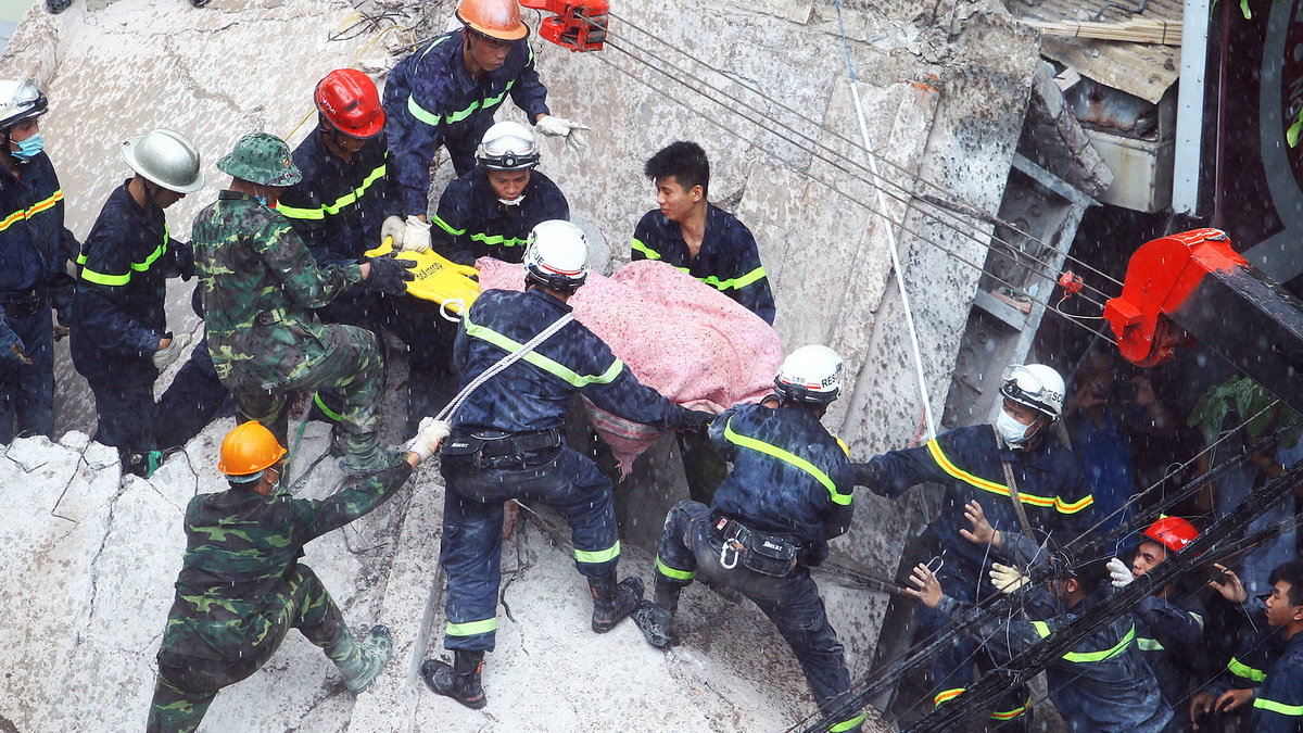 Nạn nhân cuối cùng (đã tử vong) trong vụ sập nhà trên phố Cửa Bắc đã được đưa ra khỏi đống đổ nát - Ảnh: Nguyễn Khánh