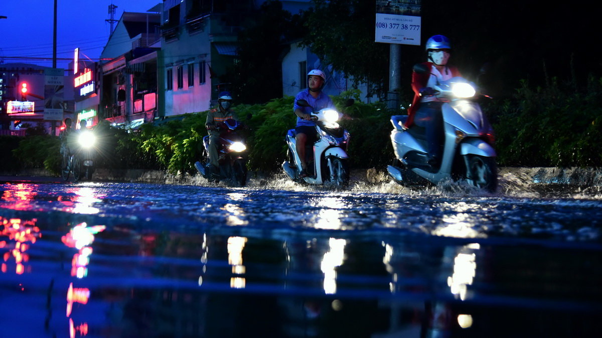 Người dân sống trên đường Phú Thuận, Q.7 cho biết nước chảy ngược từ cống lên nên nước triều đọng trên mặt đường rất hôi - Ảnh: HỮU THUẬN