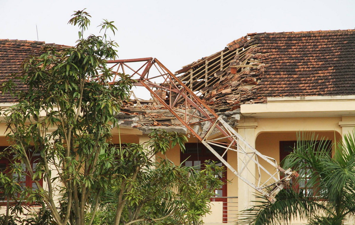 Cần cẩu tháp đổ sập vắt qua mái nhà 3 tầng Trường THPT Lê Viết Thuật - Ảnh: DOÃN HÒA