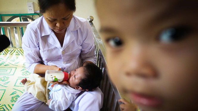 Chị Lê Thị Trạm đang cho bé Kiều U Não đứa trẻ nhỏ tuổi nhất được chuyển từ Chùa Bồ Đề uống sữa