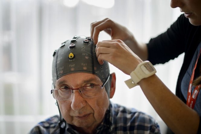 Người tham gia thí nghiệm đội mũ gắn điện não đồ - Ảnh: AFP