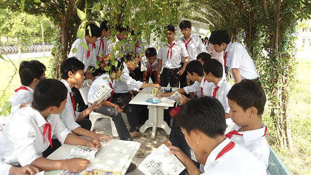 Học sinh đọc truyện, đánh cờ... trong giờ ra chơi ở “Thư viện xanh” của Trường THCS Vĩnh Thành - Ảnh: T.N.