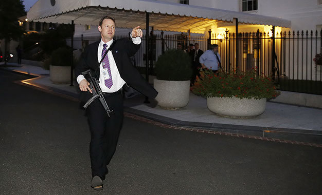 Một nhân viên mật vụ Mỹ cầm súng tuần tra quanh Nhà Trắng sau vụ xâm nhập - Ảnh: Reuters