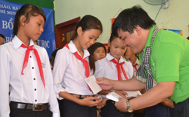 Phó tổng biên tập báo Tuổi Trẻ Lê Thế Chữ trao học bổng cho học sinh nghèo Lý Sơn - Ảnh: T.Mai