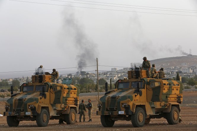 Binh lính và xe bọc thép Thổ Nhĩ Kỳ canh gác chốt kiểm soát ở biên giới với Syria - Ảnh: Reuters