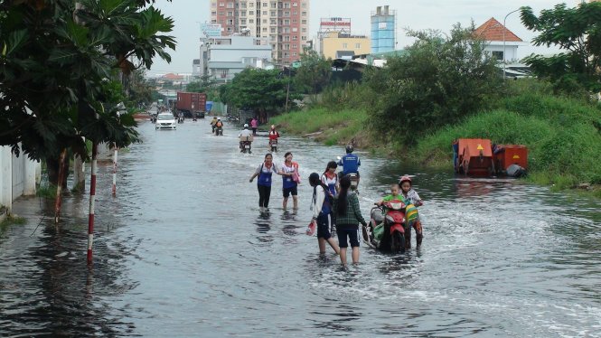 Người dân, sinh viên lội nước cống để về nhà. Ảnh: Đức Phú