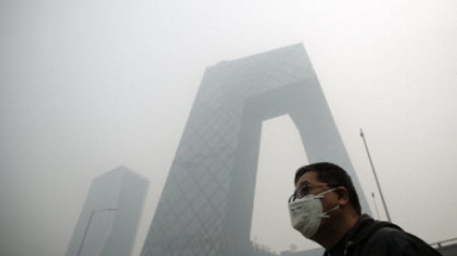 Một người đàn ông mang khẩu trang chống độc đi trong bầu không khí ô nhiễm của Bắc Kinh hôm 10-10 - Ảnh: Reuters