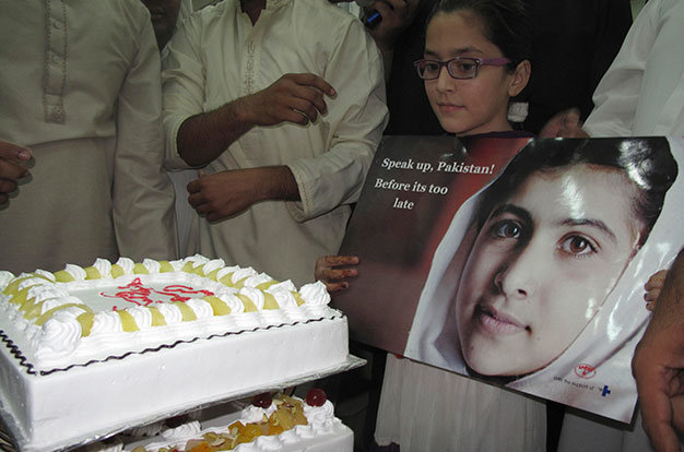 Học sinh trường nữ ở thành phố Mingora với bức ảnh Malala Yousafzai trước khi cắt bánh mừng sự kiện Malala đoạt giải Nobel hòa Bình - Ảnh: Reuters 