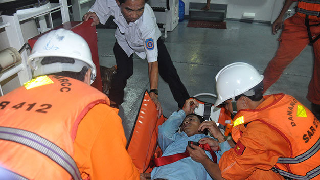 Bác sĩ Quang (áo trắng) chỉ đạo đội cứu hộ cấp cứu một ngư dân - Ảnh: T.V.