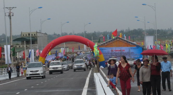 Đoàn xe và người dân qua cầu sau lễ phát động thông xe tiểu dự án - Ảnh: Hồ Văn