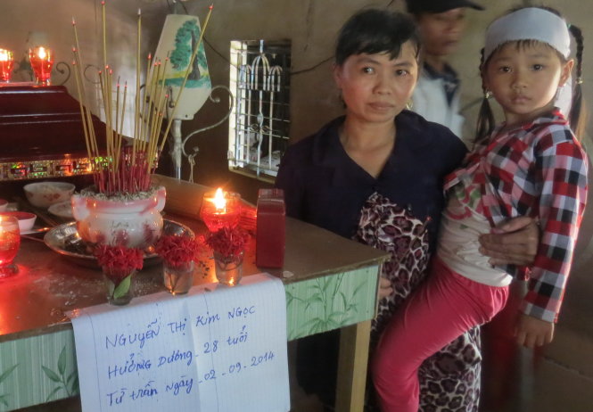 Bé Nguyễn Thị Cẩm Huyền, con chị Ngọc, bên bàn thờ mẹ - Ảnh: Đ.Vịnh