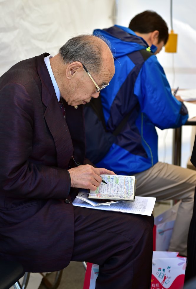 Một người cao tuổi Hàn Quốc điền vào đơn xin việc tại trung tâm giới thiệu việc làm - Ảnh: AFP
