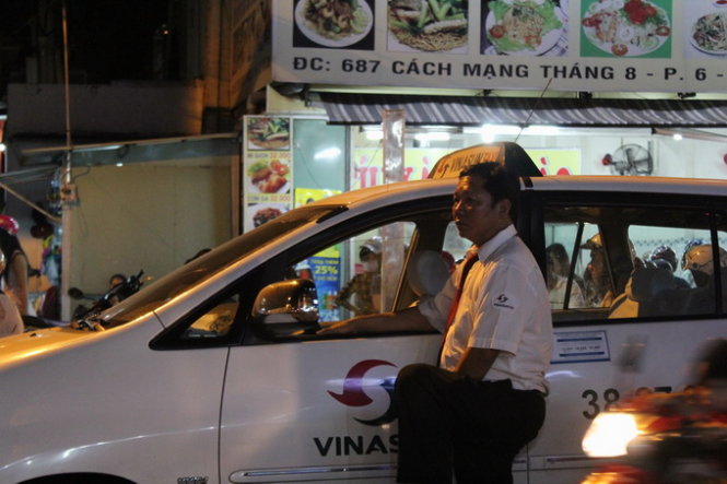 Một tài xế taxi chờ đợi hơn 2 giờ đồng hồ vì kẹt xe nên phải ra ngoài đứng cho thoáng (Ảnh: Nguyên Phong)