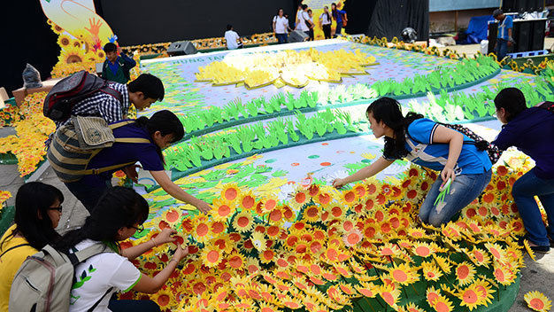 Các tình nguyện viên và bạn trẻ tham dự chương trình cắm hoa hướng dương tại cánh đồng hoa hướng dương và bàn tay tại ngày hội Hoa hướng dương sáng 2-11 ở TP.HCM - Ảnh: Quang Định