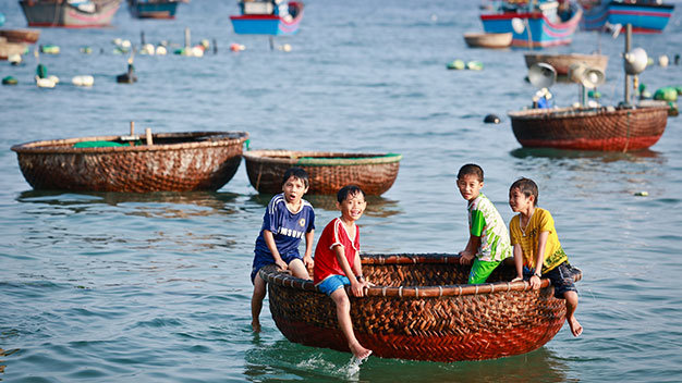 Những đứa trẻ chơi trên thuyền thúng ở làng chài Từ Nham, xã Xuân Thịnh - Ảnh: Tiến Thành
