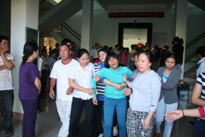 Vợ bị cáo Nguyễn Bá Giáp (mặc áo xanh dương) đã khóc ngất sau khi nghe tòa tuyên án, vì cho rằng mức án phạt 15 năm tù đối với bị cáo Giáp là quá nặng. Ảnh: Phan Sông Ngân
