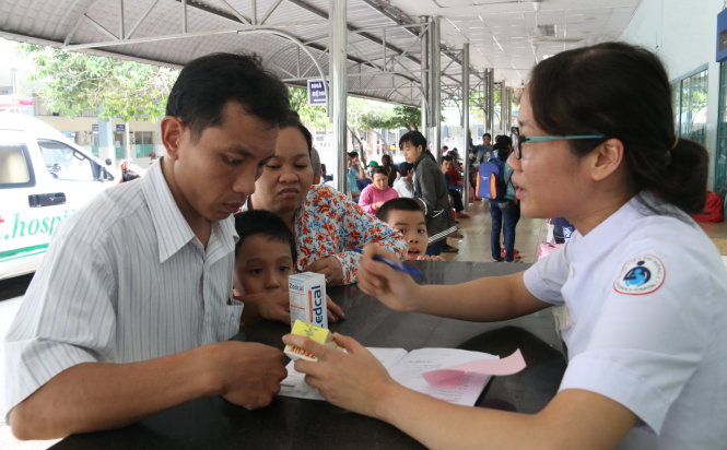 Phụ huynh nghe dược sĩ tư vấn tại bàn tư vấn dùng thuốc đặt cạnh nhà thuốc Bệnh viện Nhi Đồng 1 (TP.HCM) - Ảnh: Tiến Long