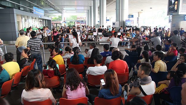 Hàng trăm hành khách ngồi chờ tại sân bay Quốc tế - Ảnh: Mậu Trường