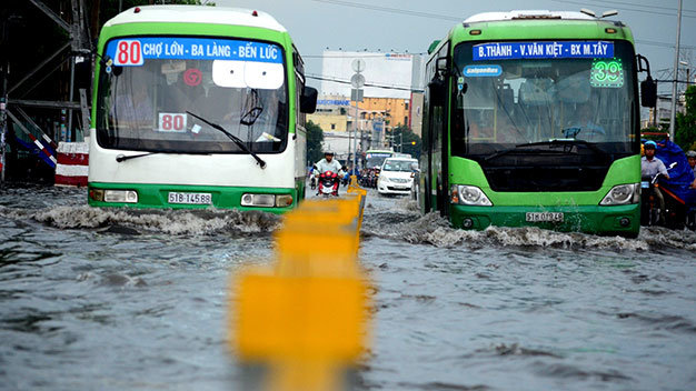 Hai chiếc xe bus “đua” trong dòng nước - Ảnh: Thanh Tùng