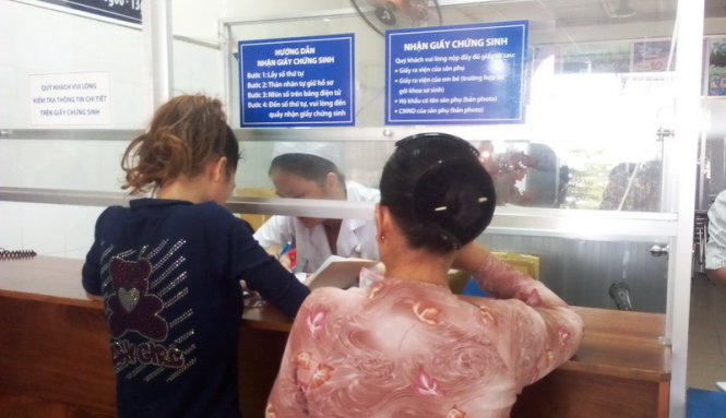 Chị Vân (bên trái) lấy giấy chứng sinh tại Bệnh viện Từ Dũ - Ảnh: Hải Hiếu