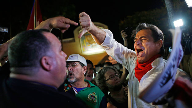 Tại Mỹ, những người ủng hộ quyết định của Tổng thống Obama (phải) đã đối đầu với những người chống lại chuyện bình thường hóa với Cuba ngay tối 17-12 tại Miami - Ảnh: Reuters