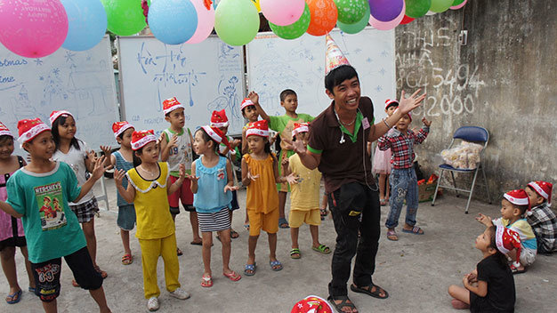 “Thầy giáo” Lê Giàu Sang nhảy nhót vui đùa với các em nhỏ trong lễ Giáng sinh giản dị trên vỉa hè - Ảnh: Hải Thi
