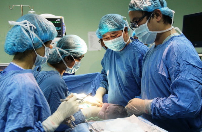 Các bác sĩ tiến hành phẫu thuật đưa một em bé ra đời bằng phương pháp thụ tinh trong ống nghiệm từ bụng mẹ - Ảnh: Phan Thành
