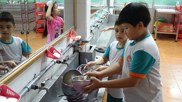 Học sinh tự rửa chén sau bữa ăn khuya lúc 20g45 tại Trường tiểu học Nhựt Tân, Q.Gò Vấp, TP.HCM - Ảnh: Như Hùng