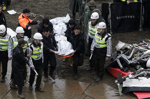 Nhân viên cứu hộ đưa thi thể một nạn nhân lên bờ - Ảnh: Reuters