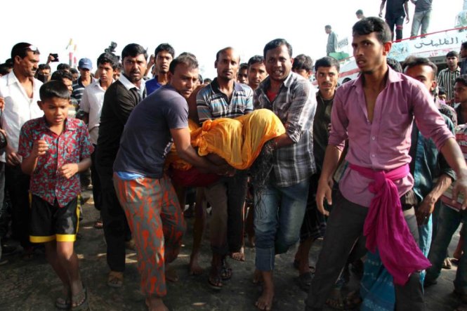 Người dân Bangladesh đang khiêng thi thể một nạn nhân trong vụ chìm phà tại quận Manikganj, cách thủ đô Dhaka về phía tây khoảng 30 km - Ảnh: AFP