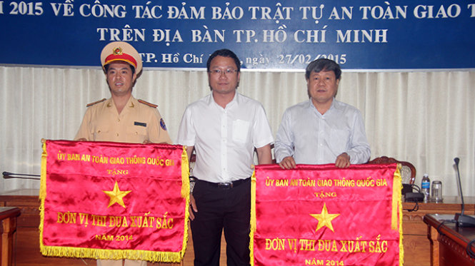 Ông Khuất Việt Hùng – phó chủ tịch UB an toàn giao thông quốc gia trao cờ thi đua cho Phòng cảnh sát đường bộ - đường sắt (Công an TP) và Ban an toàn giao thông TP - Ảnh: Quang Khải