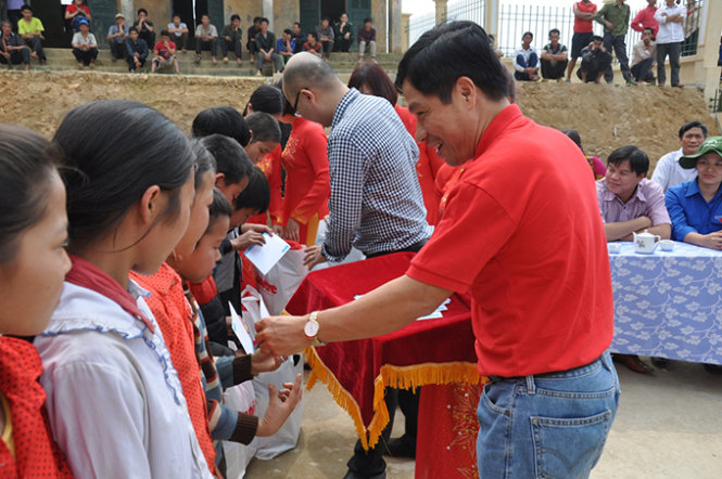 Ông Lê Nguyễn Minh Quang và nhà báo Dương Đức Đà Trang trao quà cho các em học sinh