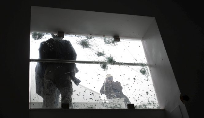 Một người đang chụp ảnh các vết đạn sau vụ khủng bố tại bảo tàng quốc gia Bardo ở thủ đô Tunis, Tunisia - Ảnh: Reuters