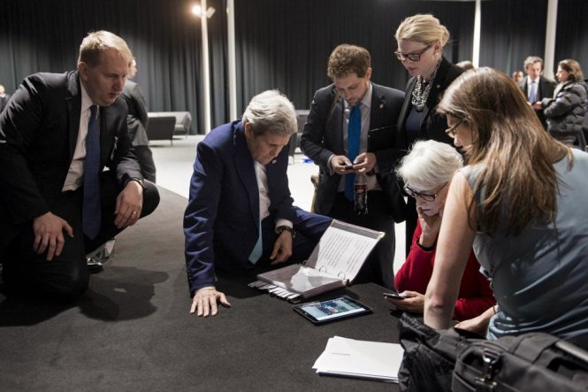 Ngoại trưởng Mỹ John Kerry (thứ 2 từ trái sang), Thứ trưởng chuyên trách Các vấn đề Chính trị Wendy Sherman (thứ 2 từ phải sang) và nhân viên đang xem Tổng thống Mỹ Barrack Obama tuyên bố về tình trạng của các cuộc đàm phán chương trình hạt nhân của Iran ngày 2/4/2015 qua một chiếc máy tính bảng tại thành phố Lausanne, Thụy Sĩ. Một thỏa thuận hạt nhân sơ bộ giữa Iran và sáu cường quốc thế giới là một cơ sở vững chắc cho một hiệp ước trong tương lai có thể chấm dứt bế tắc hạt nhân kéo dài 12 năm giữa Tehran và phương Tây, mặc dù các chi tiết phải được làm rõ, Ngoại trưởng Mỹ John Kerry cho biết vào hôm thứ Năm - Ảnh:  Brendan Smialowski
