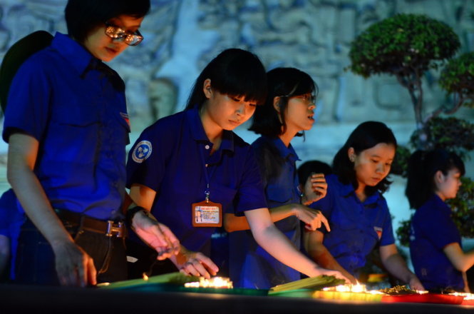 Đoàn viên thanh niên thắp nến tri ân các anh hùng liệt sĩ tại Nghĩa trang Thành phố vào đêm 25-4 -Ảnh: Thanh Tùng