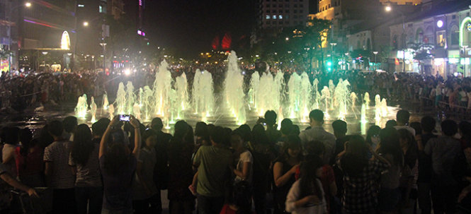 Khu vực phun nước kết hợp ánh sáng nghệ thuật trên đường Nguyễn Huệ thu hút hàng trăm người dân đến xem tối ngày 28-4 - Ảnh: Quang Khải