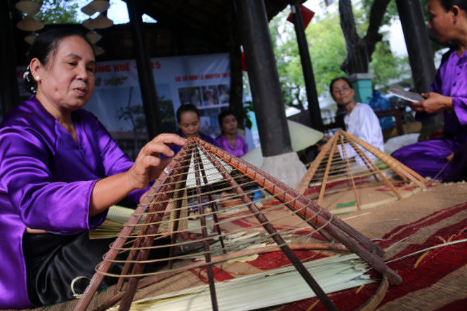 Các o, các chị làng Thủy Thanh (Hương Thủy, Thừa Thiên - Huế) trình diễn nghề làm nón lá - Ảnh: Ngọc Hiển
