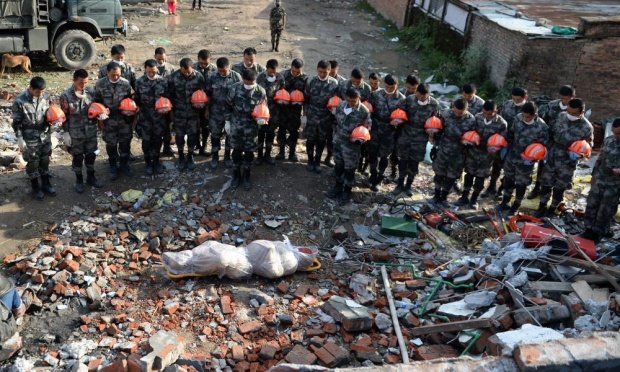 Đội cứu hộ động đất  đến từ Trung Quốc bày tỏ tiếc thương sau khi tìm thấy một thi thể bị chôn vùi trong đống đổ nát ở vùng ngoại ô Kathmandu, Nepal - Ảnh: Xinhua/Landov/Barcroft Media