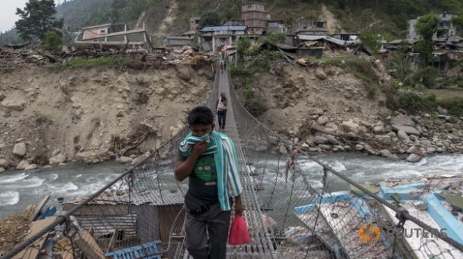 Một cư dân Nepal đang đi ngang đống đổ nát sau động đất  -  Ảnh: AFP