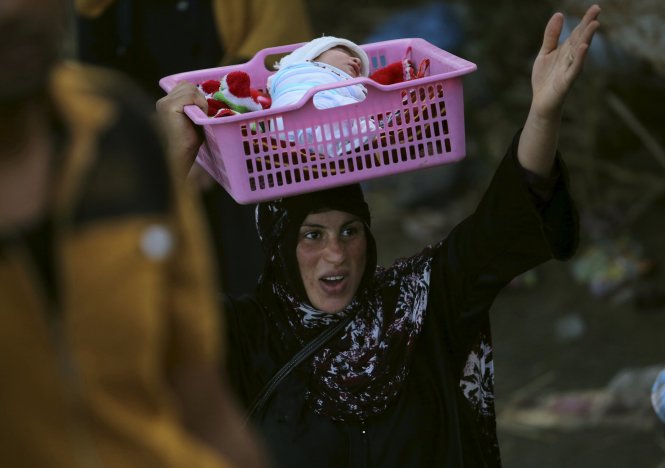 Người phụ nữ Hồi giáo Sunni Iraq đội con lánh nạn từ Ramadi về ngoại ô Baghdad ngày 19-5. Cô là một trong 40.000 người Iraq ở Ramadi phải đi lánh nạn mấy ngáy qua - Ảnh: Reuters