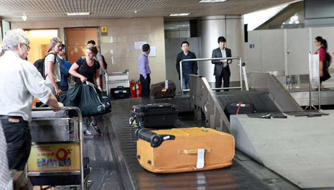 Hành khách nhận hành lý ký gửi tại sân bay Nội Bài - Ảnh: T.Phùng