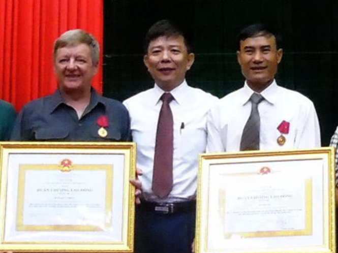 Ông Nguyễn Hữu Hoài (giữa) trao Huân chương Lao động hạng ba cho ông Howard Limbert và ông Hồ Khanh - Ảnh: L.G.