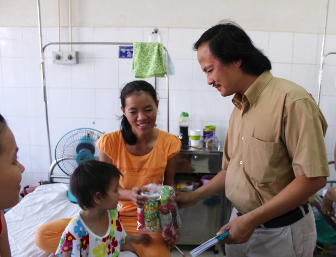 Đại diện báo Tuổi Trẻ trao quà tận tay cho các em bệnh nhi Bệnh viện Trung Ương Huế - Ảnh: Ngọc Dương