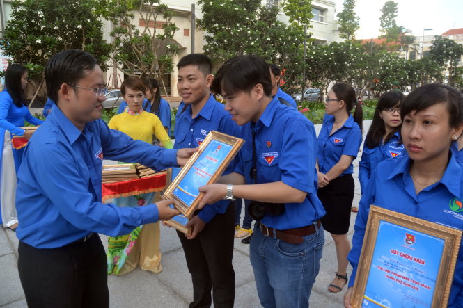 Anh Phùng Thái Quang (trái), trưởng Ban thanh niên công nhân, Thành đoàn TP.HCM, trao chứng nhận cho các thủ lĩnh thanh niên công nhân tiêu biểu - Ảnh: Q.Phương