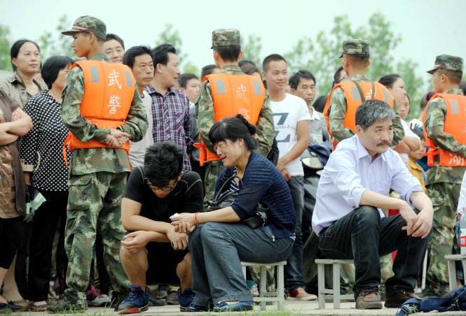 Thân nhân những hành khách tàu Ngôi Sao Phương Đông ngồi đợi chờ trong lo lắng bên bờ sông Trường Giang - Ảnh: AFP