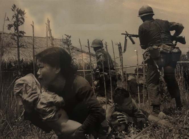 Dưới làn đạn bắn tỉa, một phụ nữ Việt Nam bế đứa trẻ đến nơi trú ẩn, trong khi thủy quân lục chiến Mỹ đang tấn công làng Mỹ Sơn, gần Đà Nẵng để tìm quân giải phóng