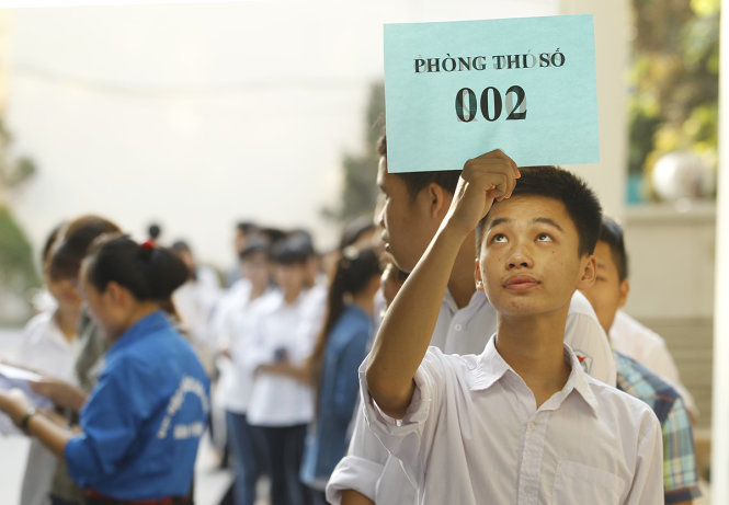 Một thí sinh cầm trên tay bảng hiệu của phòng thi tại nơi tập trung các thí sinh dự tuyển sinh bằng đánh giá năng lực lần 1 - Ảnh: Nguyễn Khánh