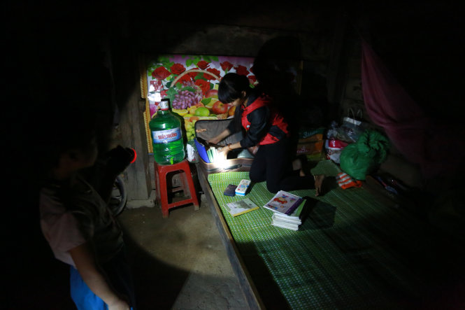 Căn chòi không có điện, Hà dùng đèn pin soi vào góc học tập của hai chị em (chính là một góc giường)